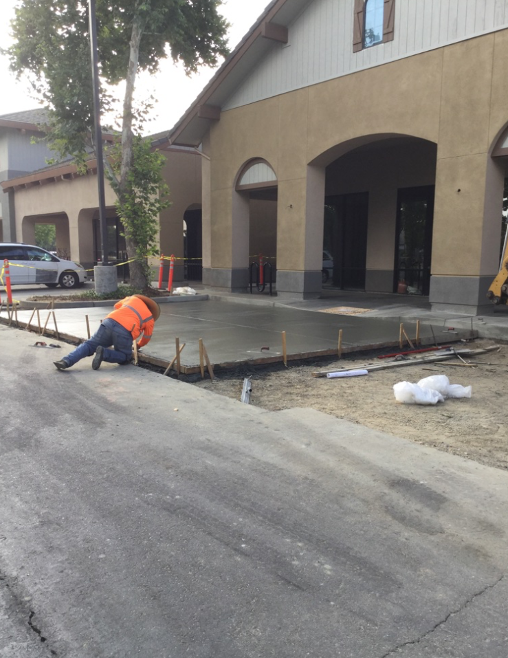 worker finishing concrete pad
