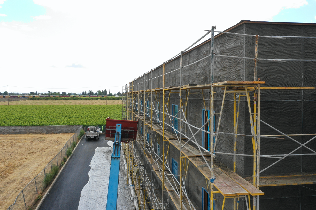 scaffolding around building green fields behind